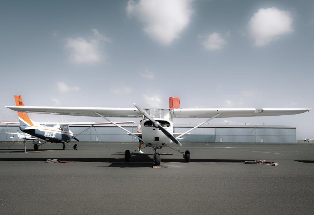 A small private airplane parked on an airfield with a clear blue sky in the background.